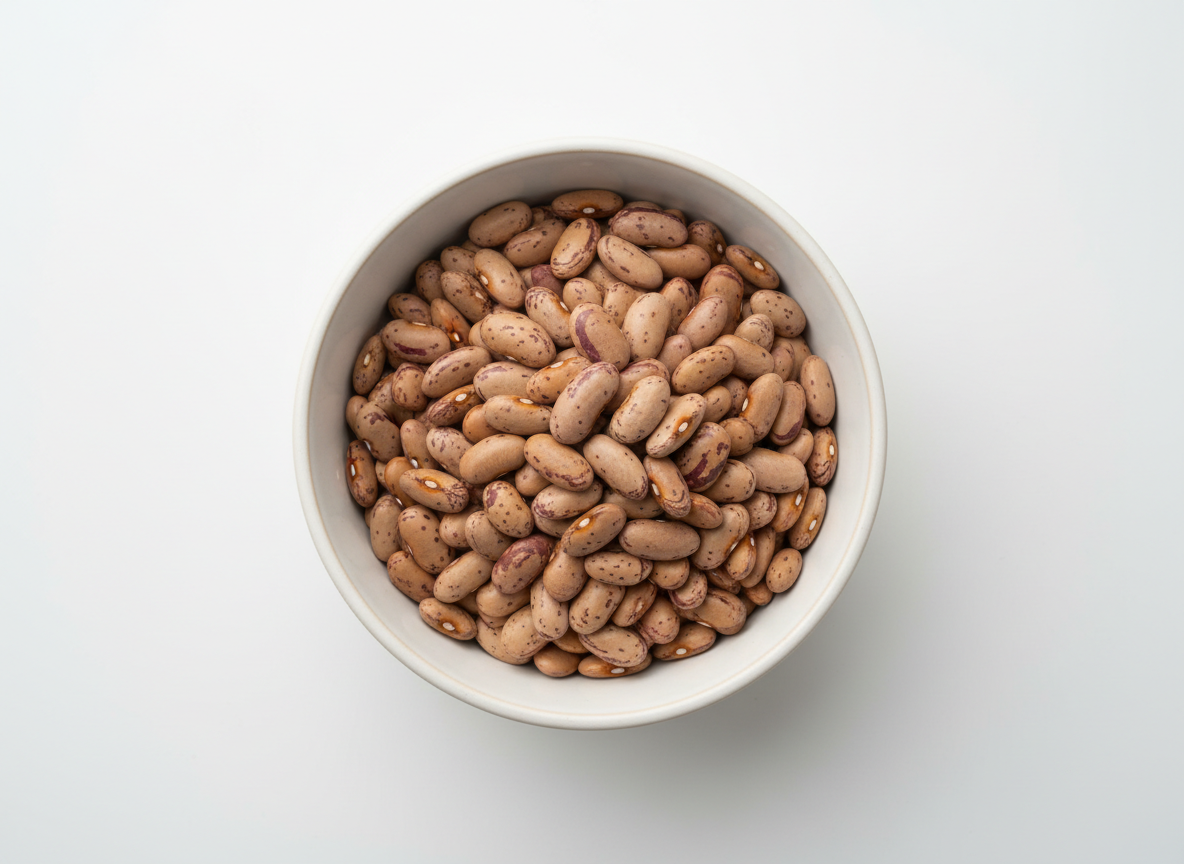 Pinto beans in a white ceramic bowl on a clean white background